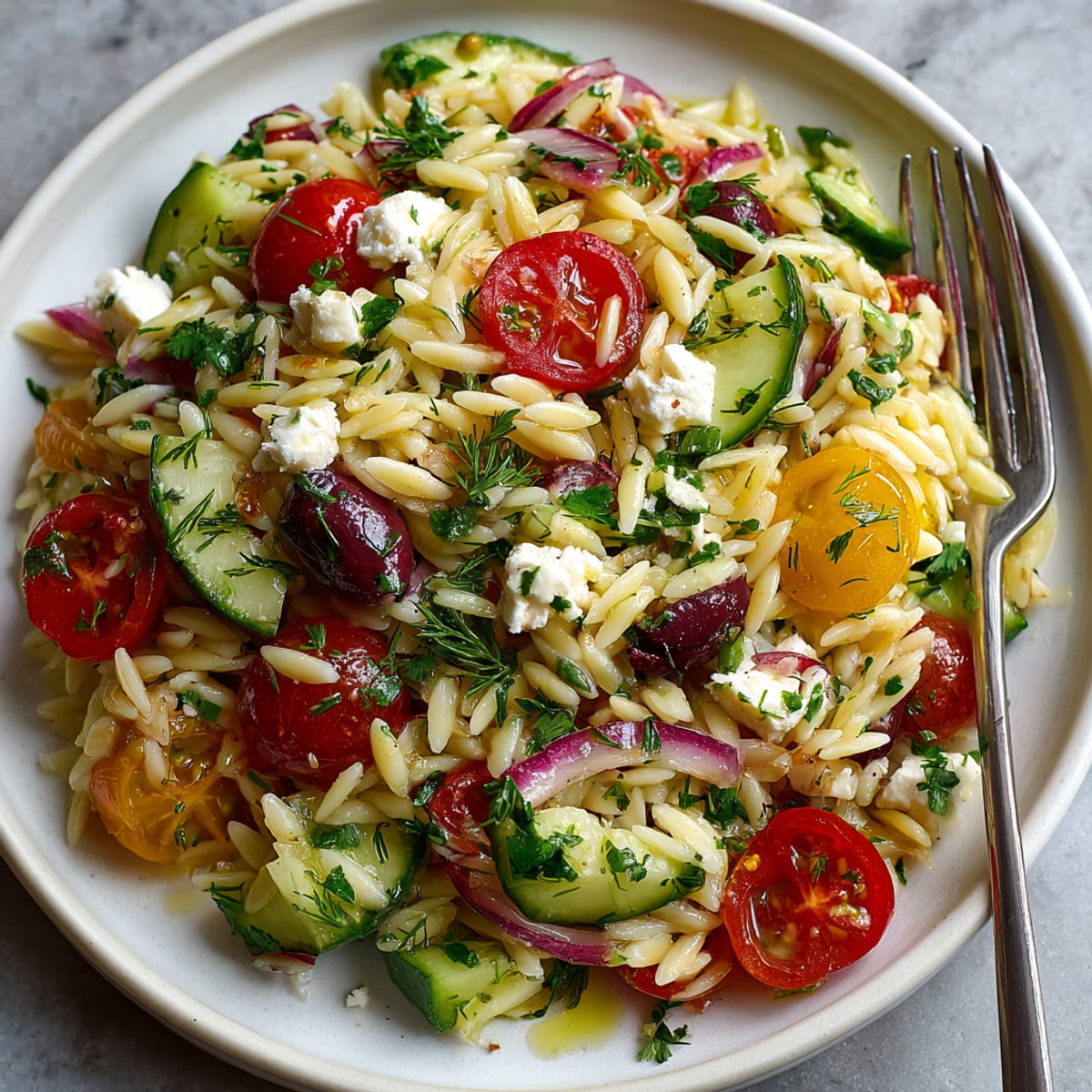 This vibrant image showcases a delicious Lemon Herb Orzo Salad, brimming with colorful vegetables and herbs.