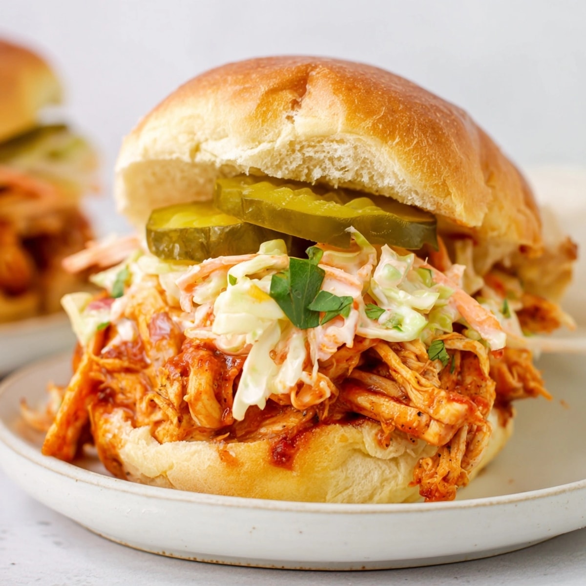 Stacked Cajun BBQ Chicken Sliders on a platter, perfect for a party appetizer.