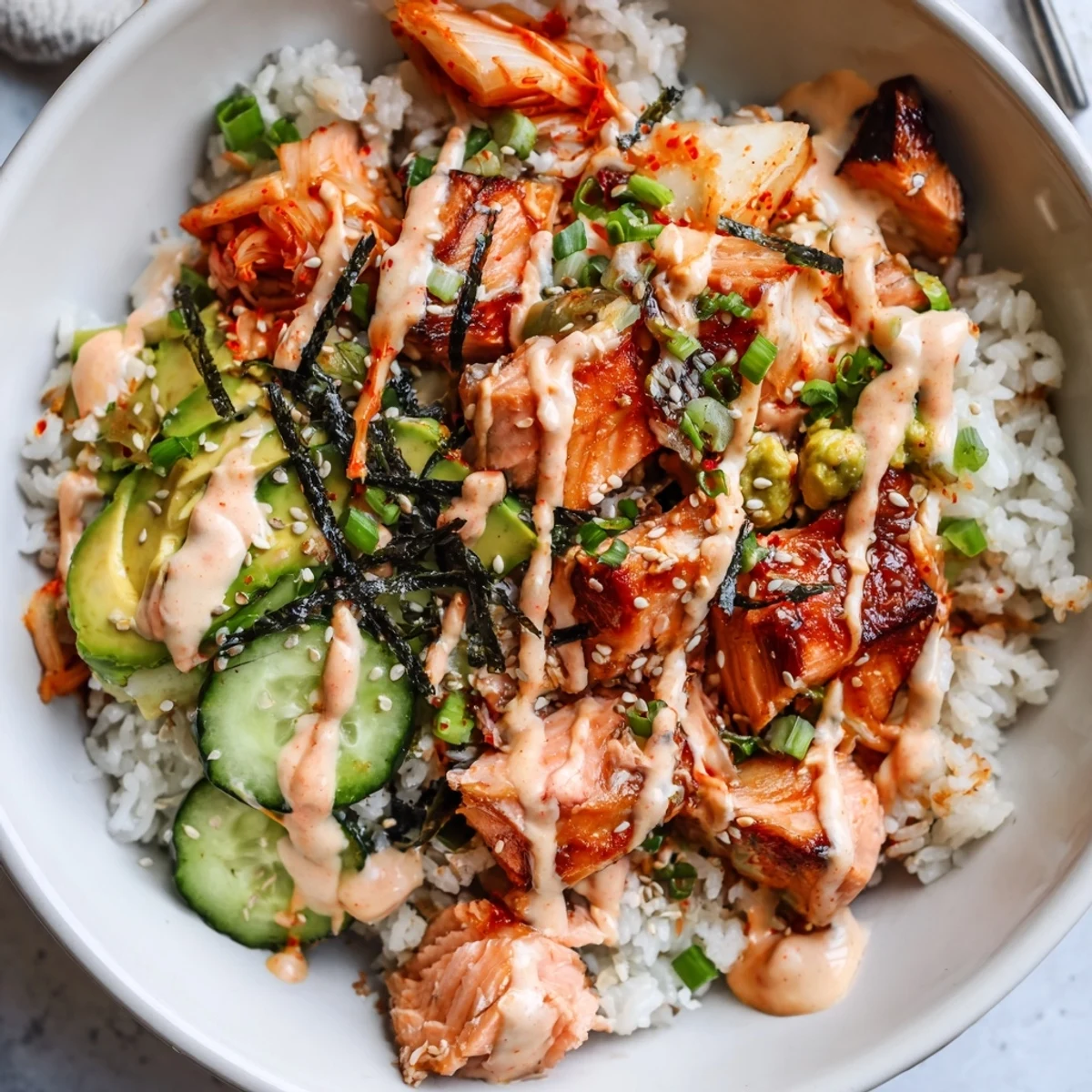 Vibrant crispy salmon rice bowl filled with textures, flavors, and colorful garnishes.  