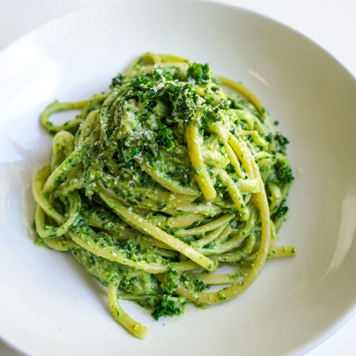 A bowl of delicious Green Goddess Pasta Sauce, ready for serving with optional extra Parmesan cheese.