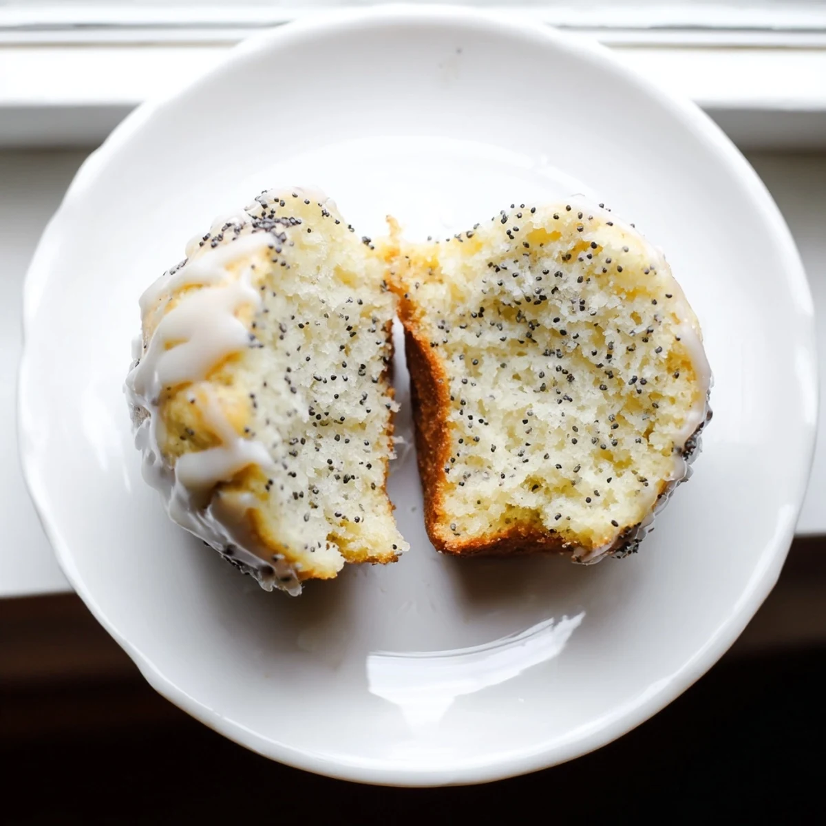 Fluffy lemon poppy seed muffins with a light glaze, offering a delightful pop of flavor and texture.