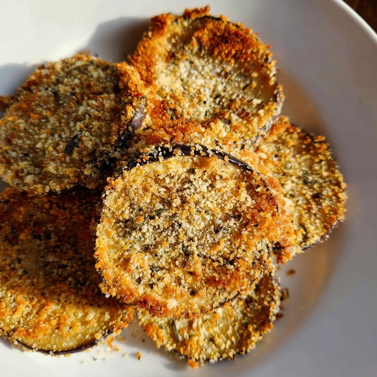 Savory Eggplant Parmesan Chips, coated in Parmesan and herbs, offer a delightful crunchy texture and flavor.