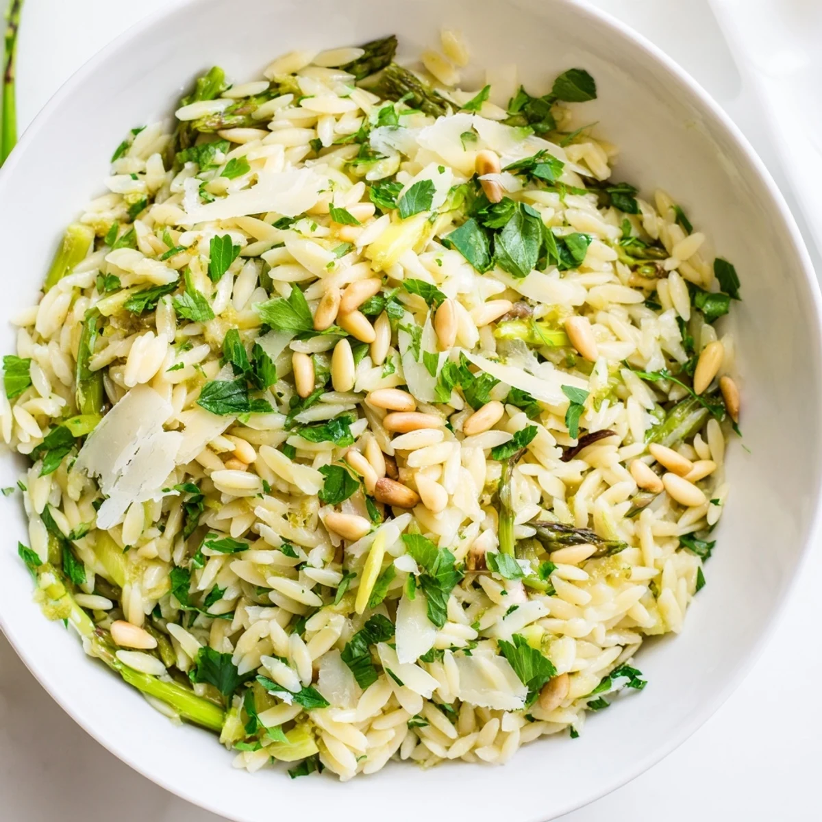 Bright green shaved asparagus ribbons, tender orzo, and Parmesan cheese tossed in a zesty lemon-olive oil dressing for this fresh Asparagus Lemon Orzo Salad.