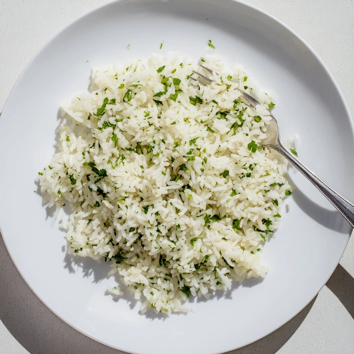 A close-up of fluffy Cilantro Lime Rice garnished with fresh herbs and citrus zest.  