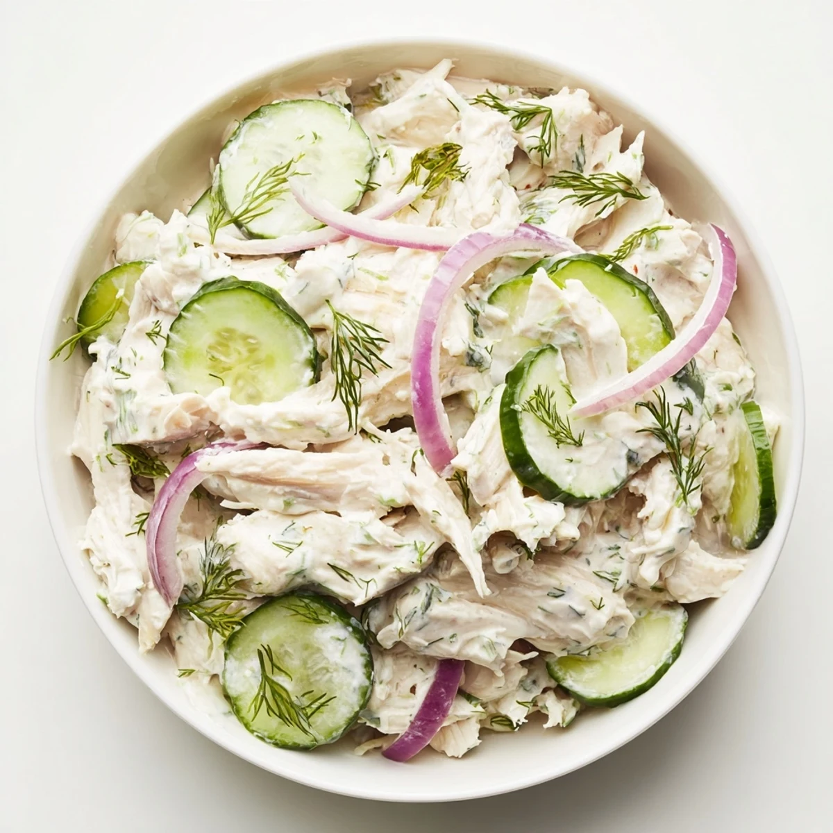 Crisp sliced cucumbers and tender shredded chicken tossed in a creamy dill yogurt dressing in a chilled bowl.  