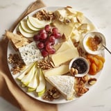 This stunning cheese platter cœur passion offers a tantalizing array of cheeses, fruits, and crackers.