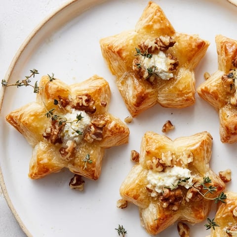 Warmly lit Starry Night New Years Appetizers, golden puff pastry stars with creamy goat cheese.