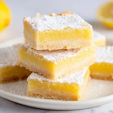 Golden lemon bars cut into neat triangles, offering a bright and zesty flavor, perfect dessert.