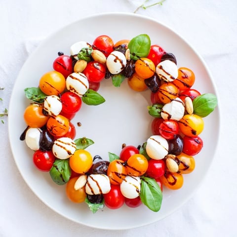 Fresh Appetizer Wreath: Cherry Tomato and Basil Ring showcases vibrant red tomatoes and creamy mozzarella drizzled with balsamic glaze.
