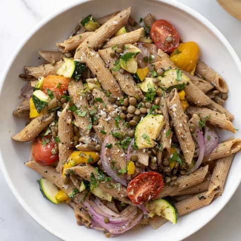 Warm and flavorful lentil pasta featuring vibrant roasted vegetables and soft lentils, ready to serve.