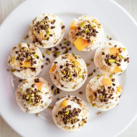 Sweet, creamy frozen peach yogurt bites, ready to enjoy as a refreshing and simple dessert today.