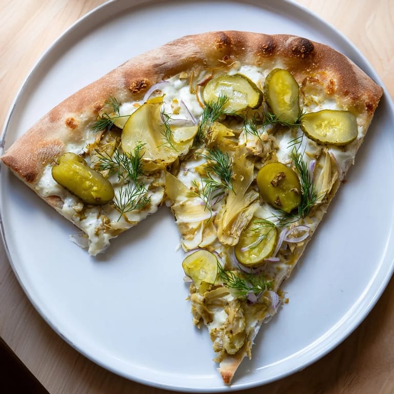 Sliced Pickle Pizza featuring golden crust and zesty crème fraîche sauce.