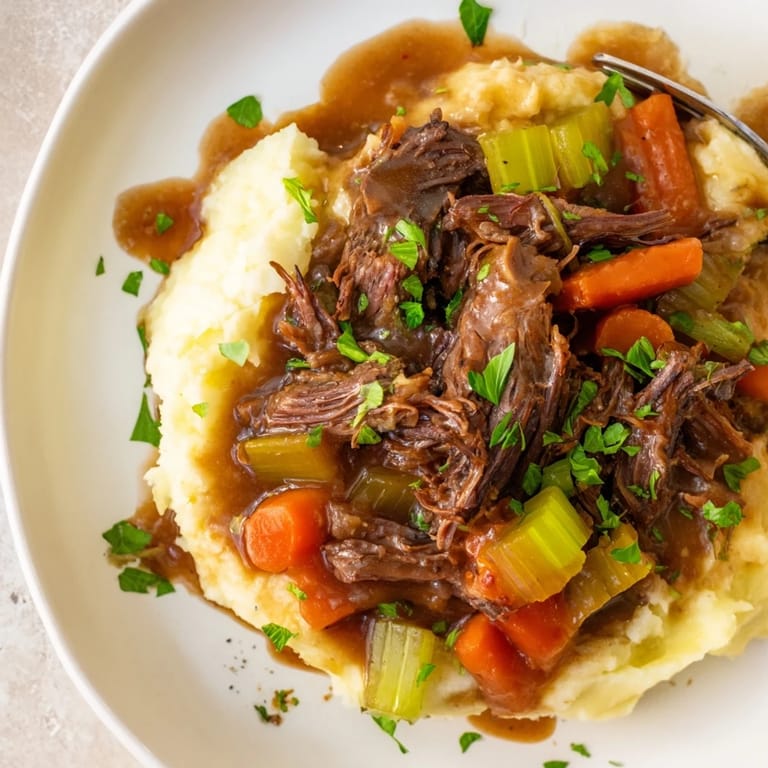 Hearty slow cooker pot roast with vibrant vegetables and buttery mashed potatoes.  
