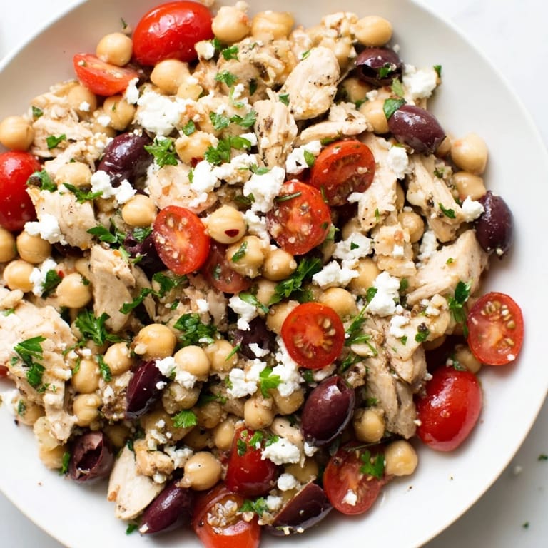 Serve this refreshing Mediterranean Chickpea Chicken Salad alongside warm pita bread on a rustic table, perfect for a light lunch or easy weeknight dinner.