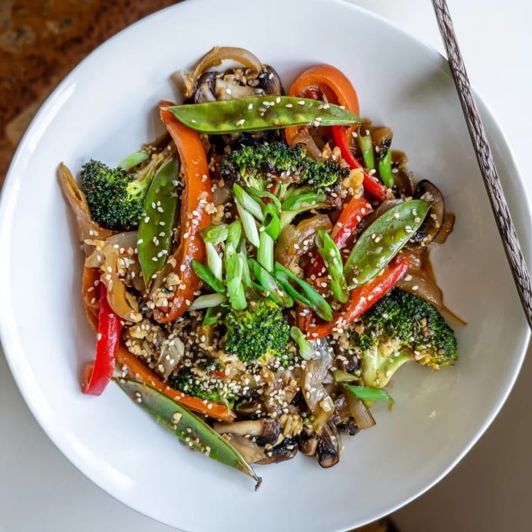 An easy vegan meal: colorful vegetables tossed with a tangy ginger-soy glaze in a hot wok for dinner.