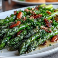 Fresh asparagus sautéed in butter with lemon and topped with toasted almonds for a bright, elegant side dish.